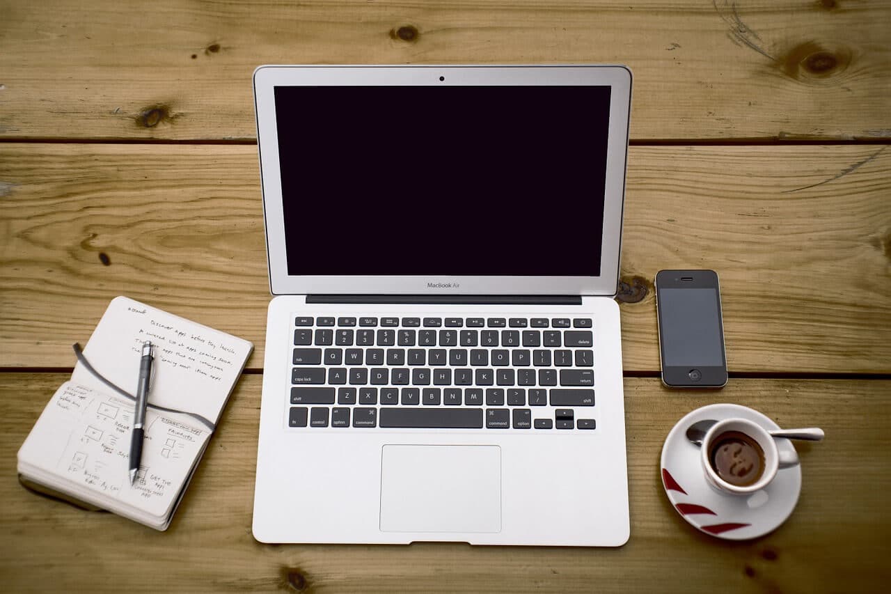 Ordinateur, carnet et tasse de café sur un bureau